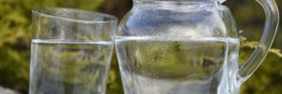 Jug of cold water beside a glass of water.