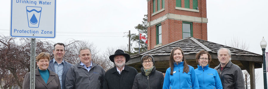 Source Protection Staff standing in front of a new sign